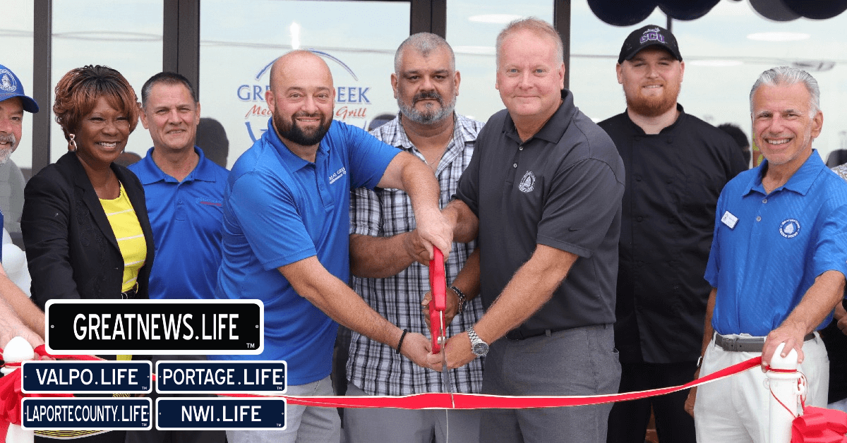 A group of people, including staff and officials, are gathered at a ribbon-cutting ceremony for Great Greek Mediterranean Grill, a new Greek fast food franchise. Two men in the center are holding large scissors to cut the ribbon. A group of people, including staff and officials, are gathered at a ribbon-cutting ceremony for Great Greek Mediterranean Grill, a new Greek fast food franchise. Two men in the center are holding large scissors to cut the ribbon.